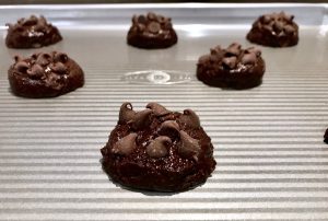 Brownie cookie dough with chocolate chips on cookie sheet