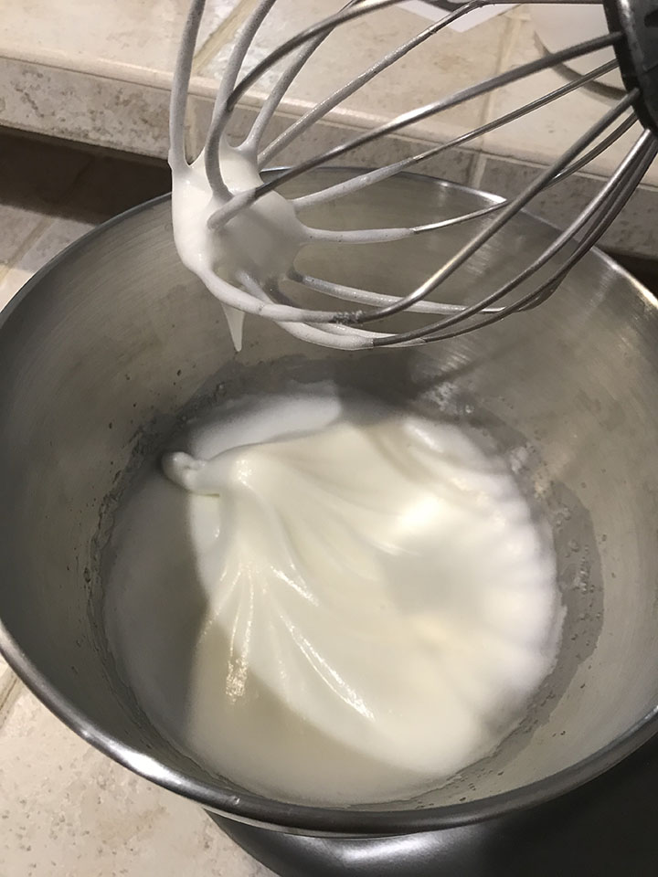 Meringue with soft peaks in mixing bowl