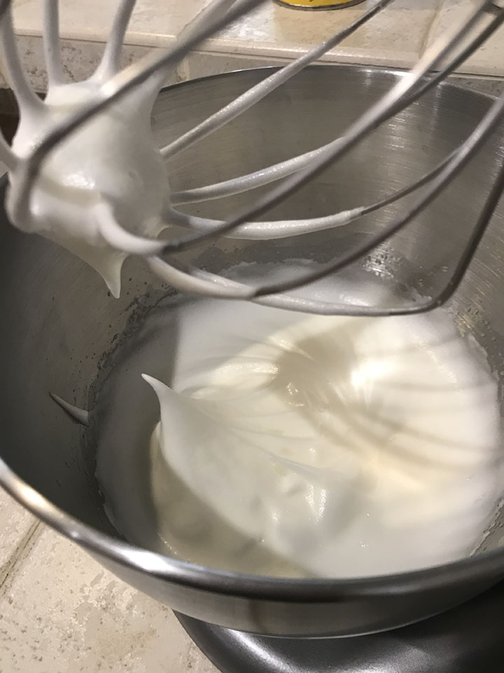 Meringue with stiff peaks in mixing bowl