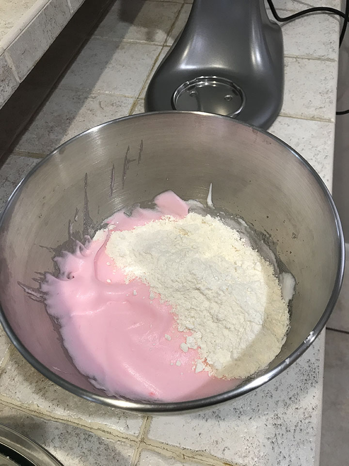 Pink meringue and almond flour in mixing bowl