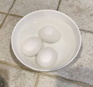 Eggs in water inside white bowl