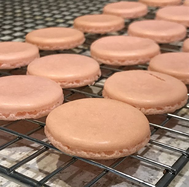 Pink macaron shells on rack